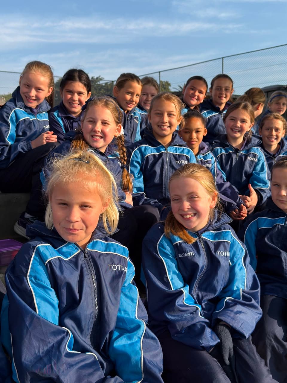 'n Groot groep senior leerders glimlag saam